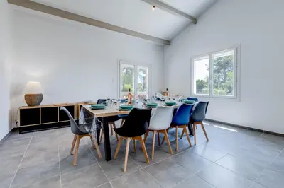 a dining room with a long table and chairs at Villa Les Cigales Velaux in Velaux