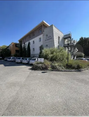 a building with cars parked in a parking lot at Joli Studio le clos d'Aix avec grande terrasse piscine et parking gratuit in Aix-en-Provence