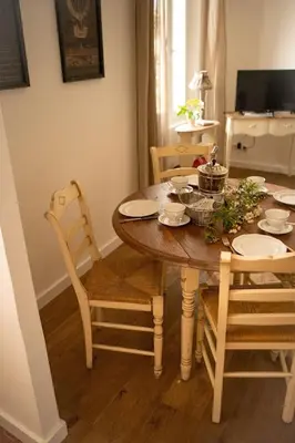 a dining room table with chairs and a table and a table at La maison du bassin in LʼIsle-sur-la-Sorgue