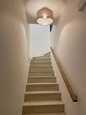 a stairway with a light fixture and a staircase with stairs at La maison du bassin in LʼIsle-sur-la-Sorgue