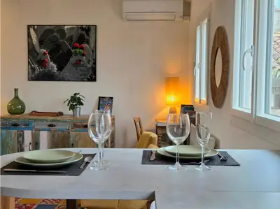 a table with two plates and wine glasses on it at 2 pièces climatisé en duplex avec terrasse in Aix-en-Provence