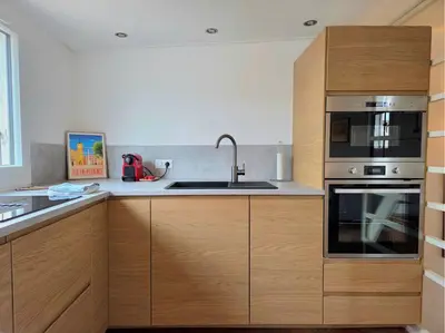 a kitchen with wooden cabinets and a sink at 2 pièces climatisé en duplex avec terrasse in Aix-en-Provence