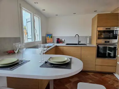 a kitchen with a table with plates and wine glasses at 2 pièces climatisé en duplex avec terrasse in Aix-en-Provence