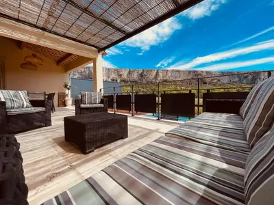 a patio with a bed and chairs on a deck at Gite La Madeleine du Luberon. in Lioux