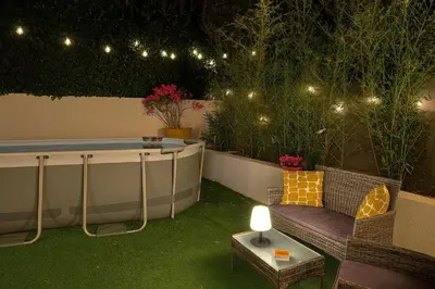 a garden with a tub and a couch and lights at Maison, Jardin, piscine parking près d'Aix Centre in Venelles