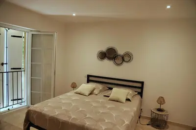a bedroom with a large bed and a balcony at Duplex de charme au coeur de la Provence. in Pertuis