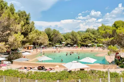 a large pool with people in it with umbrellas at Village Pont Royal en Provence - maeva Home - Appartement cosy et climatisé 2 pièces 4 personnes - Prestige - super Home MAE-2164 in Mallemort