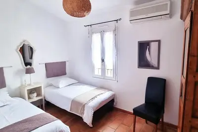 a bedroom with two beds and a chair at Villa tout confort, piscine - Au pied du VENTOUX in Saint-Didier