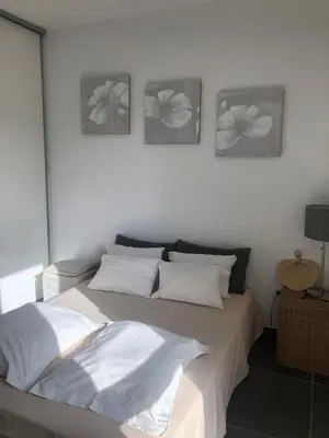 a bedroom with a bed with three pictures on the wall at Appartement Aix en Provence vue Ste Victoire - BATIMENT B11 - 13090 AIX EN PROVENCE in Aix-en-Provence