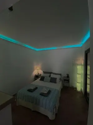 a bedroom with a bed with a blue light on the ceiling at Maisonnette à la campagne. Idéal Télétravail in Éguilles