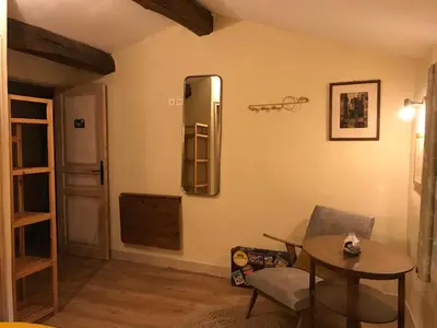 a living room with a table and a mirror at Hôtel Restaurant L’Observatoire in Saint-Michel-lʼObservatoire