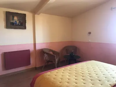 a bedroom with a bed and a tv and a table at Hôtel Restaurant L’Observatoire in Saint-Michel-lʼObservatoire