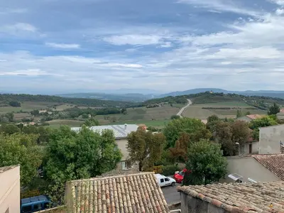 a view of a town with hills and trees at Hôtel Restaurant L’Observatoire in Saint-Michel-lʼObservatoire