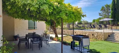 a patio with a table and chairs under a tree at La Ribasse en Provence in Venelles