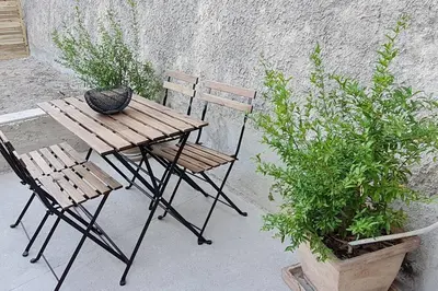 a wooden table and two chairs next to a wall at La calade in Vedène