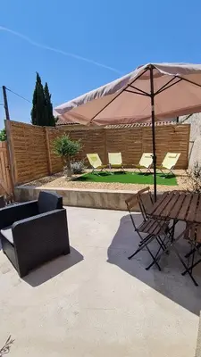 a patio with a table and chairs and an umbrella at La calade in Vedène