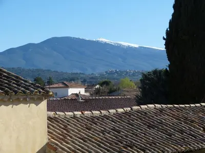 a group of roofs with a mountain in the background at Gite du domaine Saint-Marc, entre Ventoux et dentelles de Montmirail in Caromb