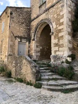 a stone building with stairs leading up to a door at La Maiz in Maubec