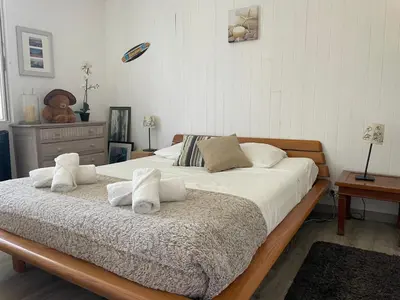 a bedroom with a large bed with white sheets and pillows at Villa avec Piscine au coeur de la campagne provençale in Lançon-Provence