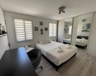 a bedroom with a bed and a desk and a mirror at Villa avec Piscine au coeur de la campagne provençale in Lançon-Provence
