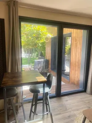 a dining room with a table and chairs and a sliding glass door at A lombre du magnolia in LʼIsle-sur-la-Sorgue
