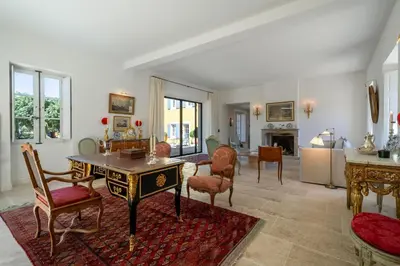 a room with two white chairs and bookshelves at Le Domaine du Fortin in Ménerbes