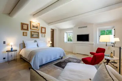 a living room with white furniture and a large window at Le Domaine du Fortin in Ménerbes