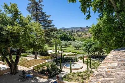 a view of a garden with a pool and trees at Le Domaine du Fortin in Ménerbes
