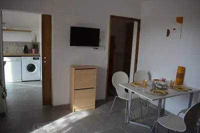 a room with a table and a kitchen with a microwave at Le mas de la joëlette in Vedène