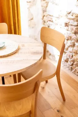 a wooden table with a wooden chair and a wooden table at La Maison des Lamanon in Salon-de-Provence