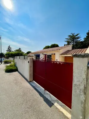 a red fence in front of a house at Maison de charme avec Jacuzzi in Mollégès