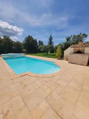 a swimming pool in a yard with a patio at Gîte élégant au calme in Mazan
