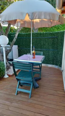 a table and a chair under an umbrella at studio 66 in Caumont-sur-Durance