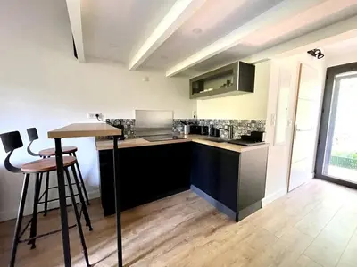 a kitchen with a counter and stools in a room at Ravissant appartement à 5min du centre ville d'Aix in Aix-en-Provence