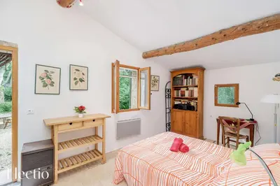 a bedroom in a house with a bed and a table at Mas du Rocher I Electio in Puget