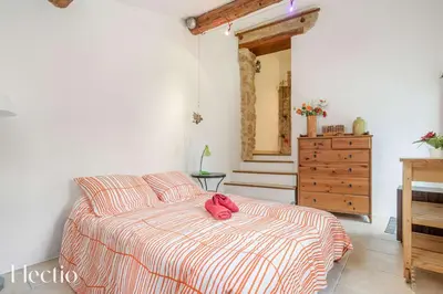 a bedroom with a bed with a red hat on it at Mas du Rocher I Electio in Puget