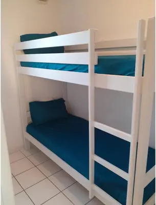 a room with two bunk beds with blue sheets at Belle Maisonette dans Residence 3* avec piscine partagée in Saint-Saturnin-lès-Avignon