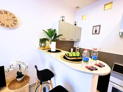 a room with a table with a cake and a clock at Carré Rouge*Gare Sncf*Fibre Wifi in Miramas