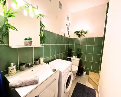 a bathroom with a sink and a toilet with plants on the wall at Carré Rouge*Gare Sncf*Fibre Wifi in Miramas