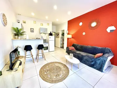 a living room with a couch and a kitchen at Carré Rouge*Gare Sncf*Fibre Wifi in Miramas