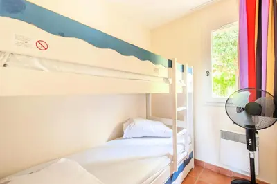 a bedroom with bunk beds with a fan and a window at Village Pont Royal en Provence - maeva Home - Maison climatisée 4 pièces 6 personnes - Sélection MAE-7054 in Mallemort