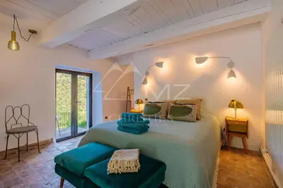 a bedroom with a large bed and a table at Superbe Mas Authentique du Luberon Courroussouvo in Oppède