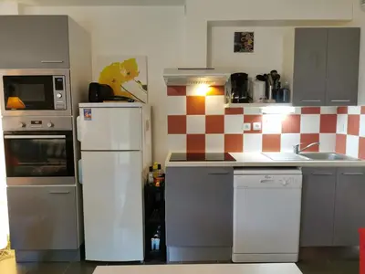a kitchen with white appliances and a checkered wall at Maison conviviale à Aubignan avec piscine partagée in Aubignan