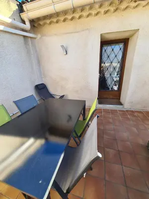 a table and chairs in a room with a window at Les oliviers in Ansouis