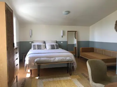 a bedroom with a bed and a couch and a chair at L’OBSERVATOIRE in Saint-Michel-lʼObservatoire
