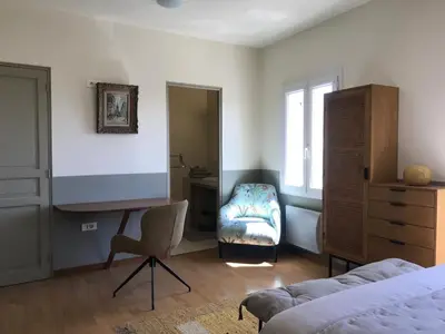 a bedroom with a bed and a desk and a chair at L’OBSERVATOIRE in Saint-Michel-lʼObservatoire