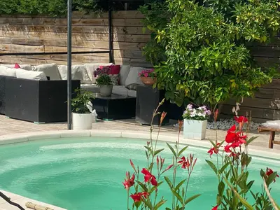 a swimming pool in a yard with plants and flowers at Villa des palmiers in Saint-Saturnin-lès-Avignon