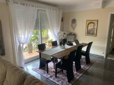 a dining room with a table and chairs and a couch at Villa des palmiers in Saint-Saturnin-lès-Avignon