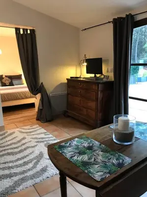 a room with a bedroom with a bed and a table at Gîte de charme La Manola in Rognes