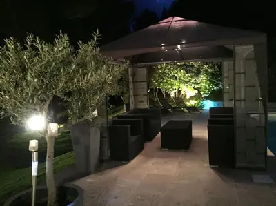 a group of chairs under an umbrella at night at Gîte de charme La Manola in Rognes